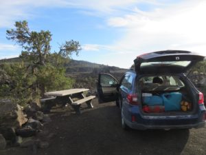 Car next to a picnic table in an old lava field